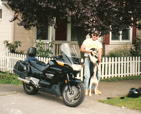 Fletcher Catron with waving doggy behind motorcycle